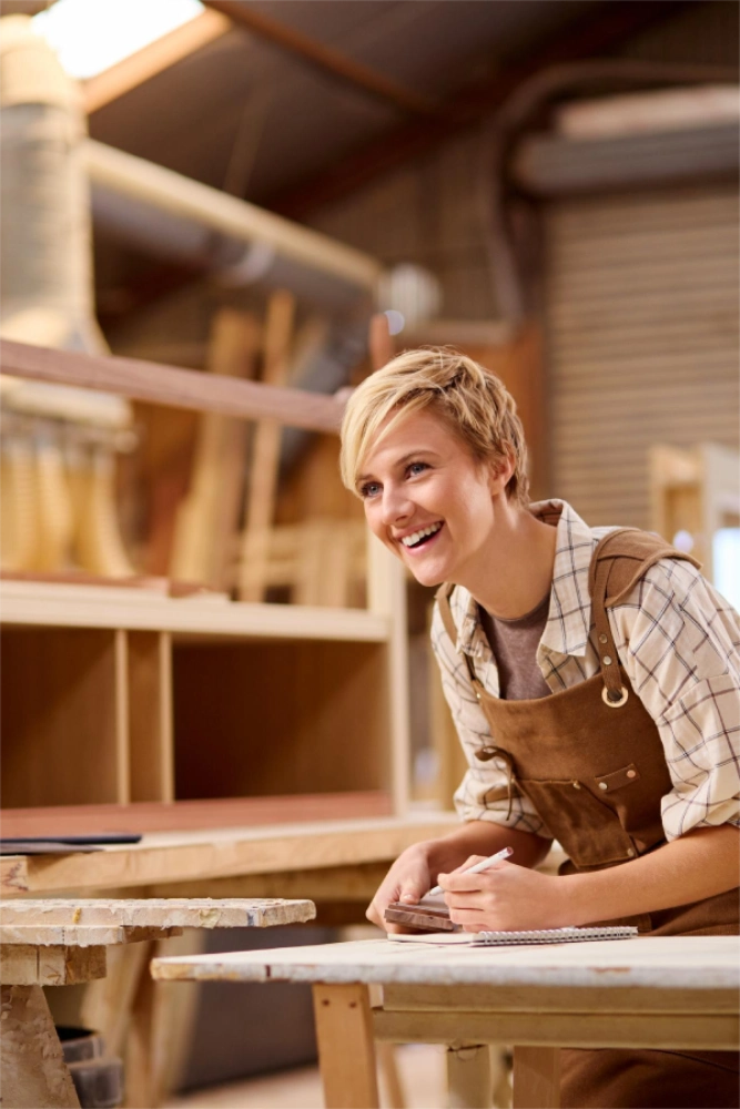 Junge Frau zeichnet mit Bleistift am Holz an - Liftung Leben und Arbeit