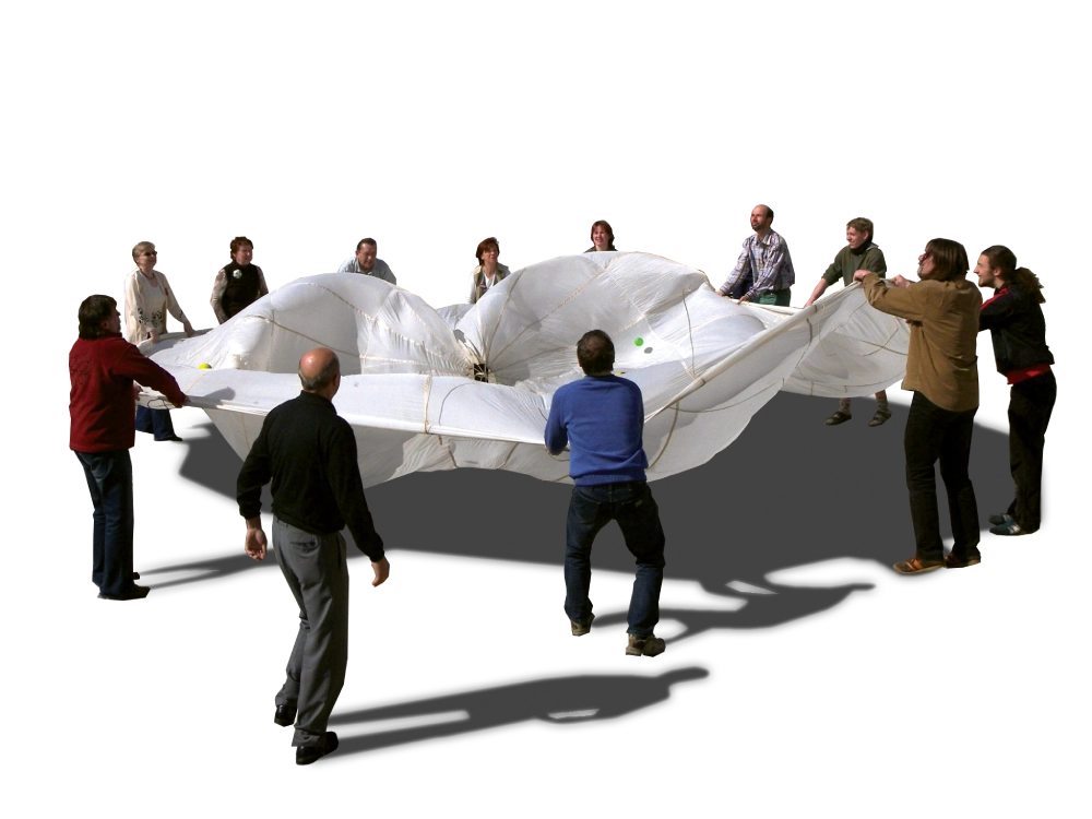 Menschen stehen im Kreis und haben ein großes Tuch in der Hand
